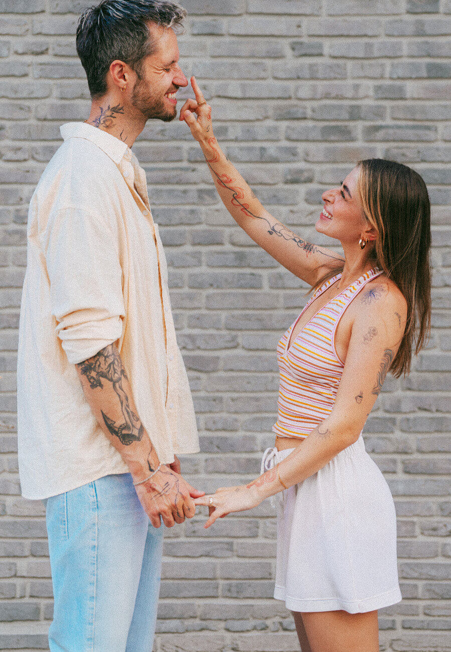DJ duo kitsch & SASH smiling and holding hands while standing together